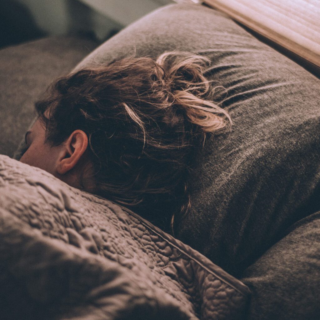 Kopf einer jungen schlafenden Frau auf einem Kissen.