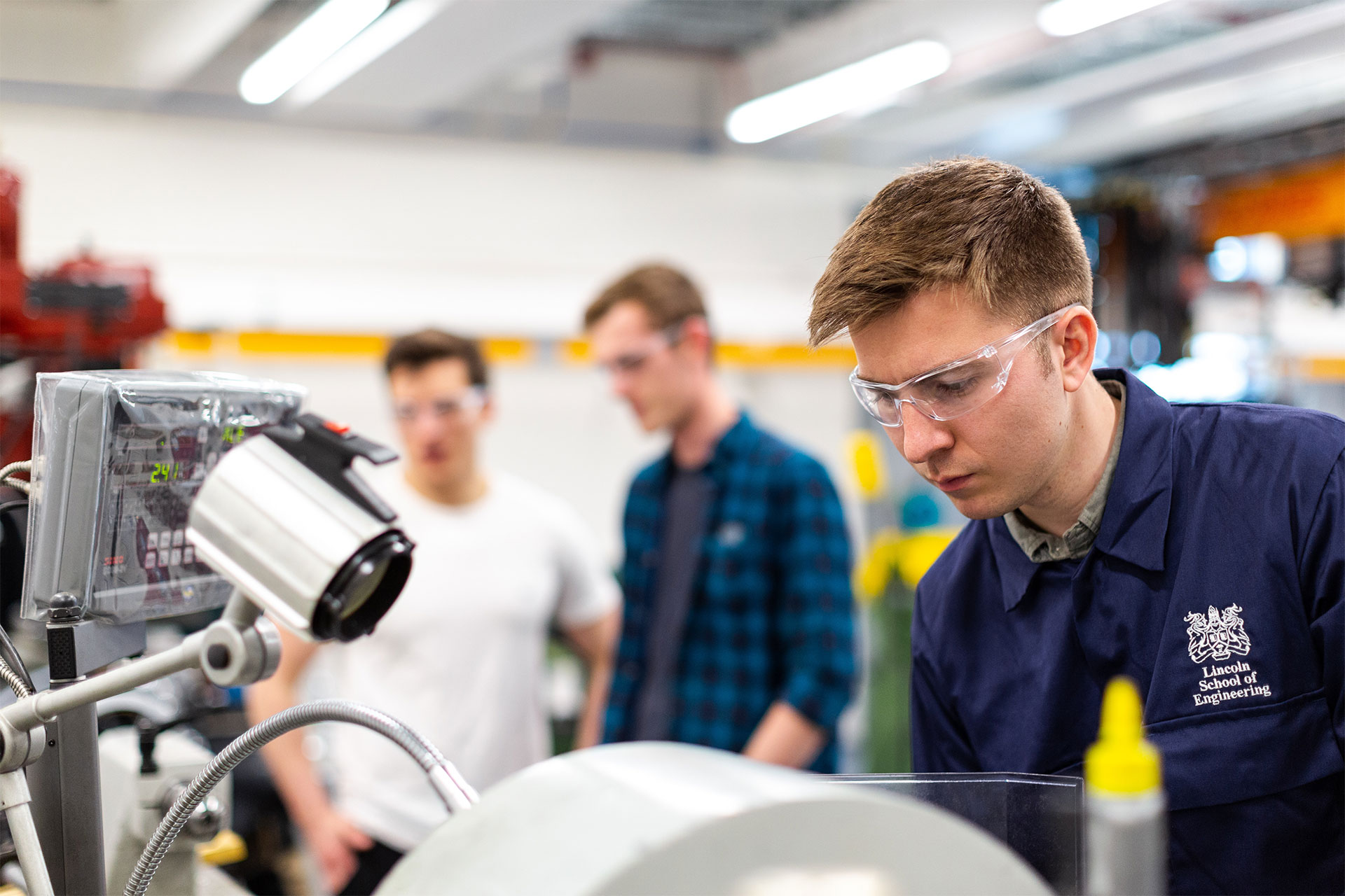 3 junge Mitarbeiter analysieren konzentiert Produktionsteile