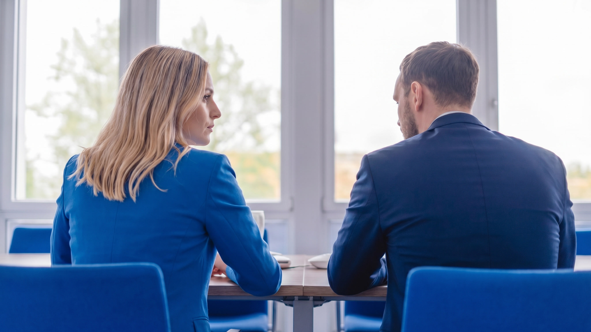 Frau sitzt mit Arbeitskollegen im Meeting
