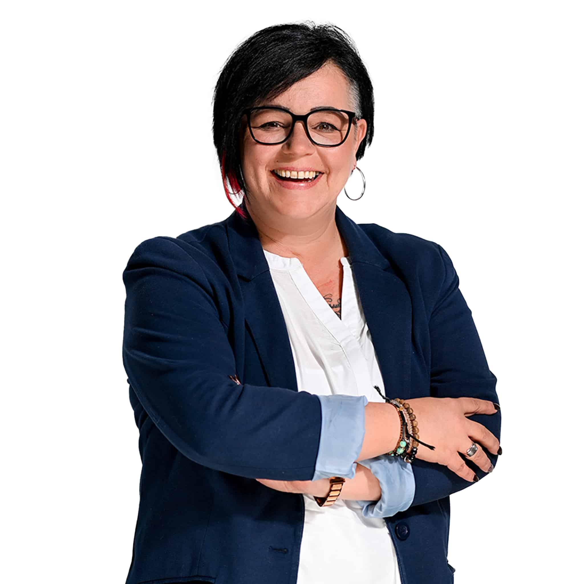 Mitarbeiterin, Doris Sailler-Glanze, lächelt und posiert mit verschränkten Armen.